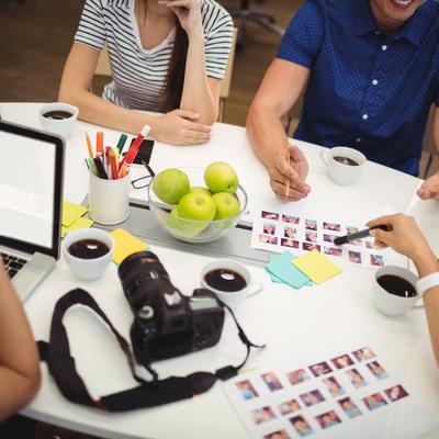 Creative team reviewing image selections with a camera and laptop