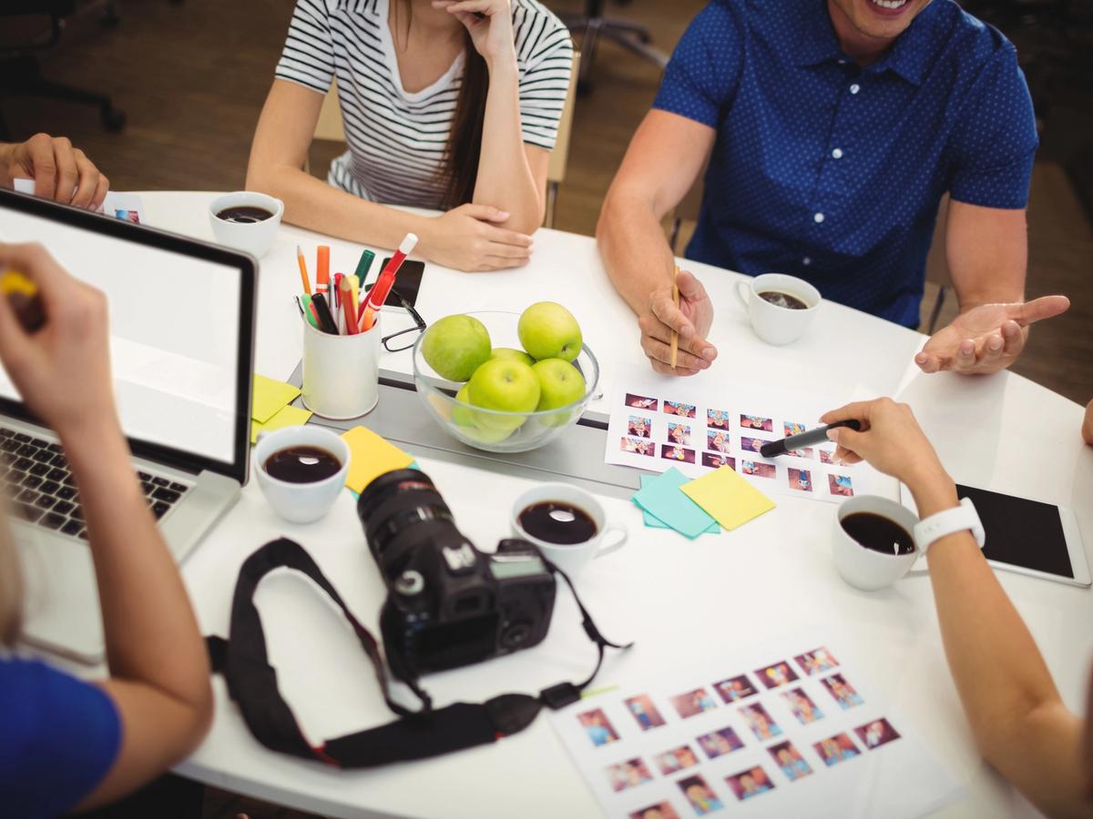Creative team reviewing image selections with a camera and laptop