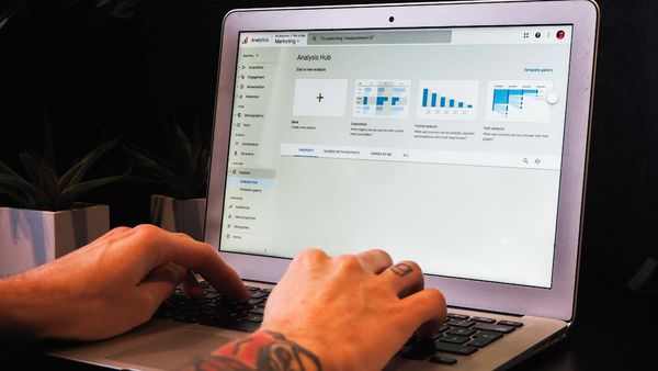person using macbook pro on table