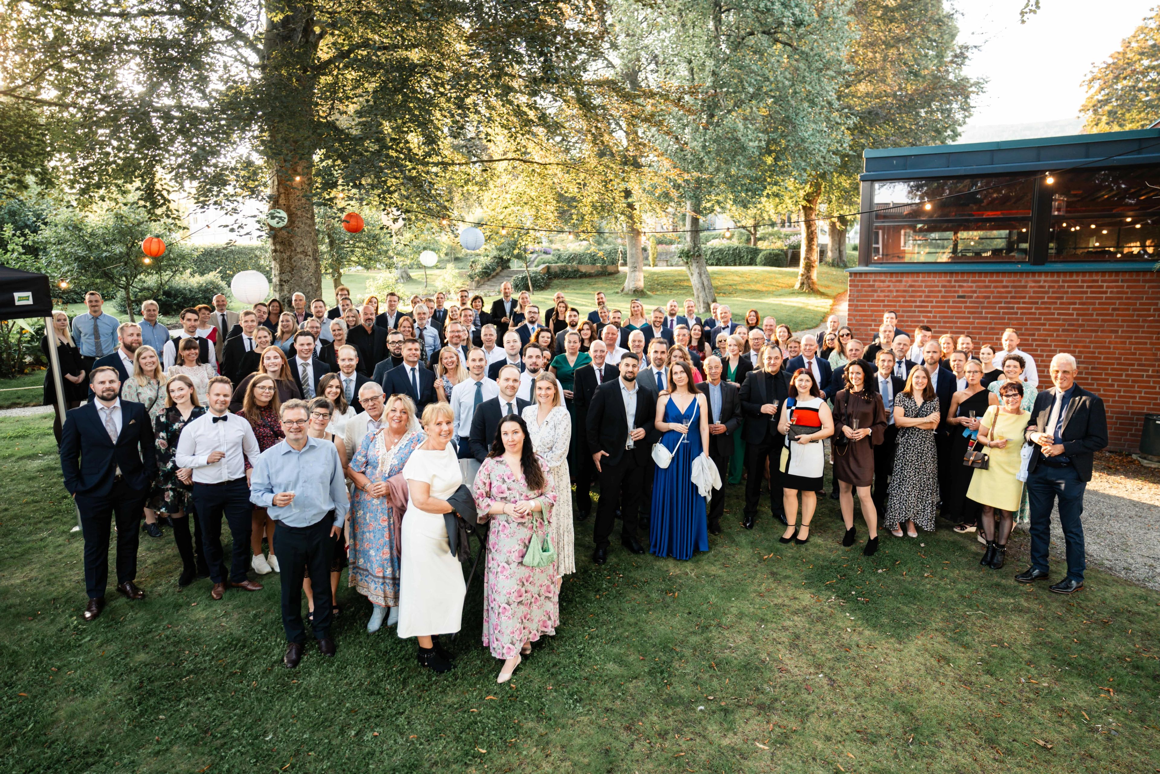 A group of pepole dressed for a party gatherd in a garden