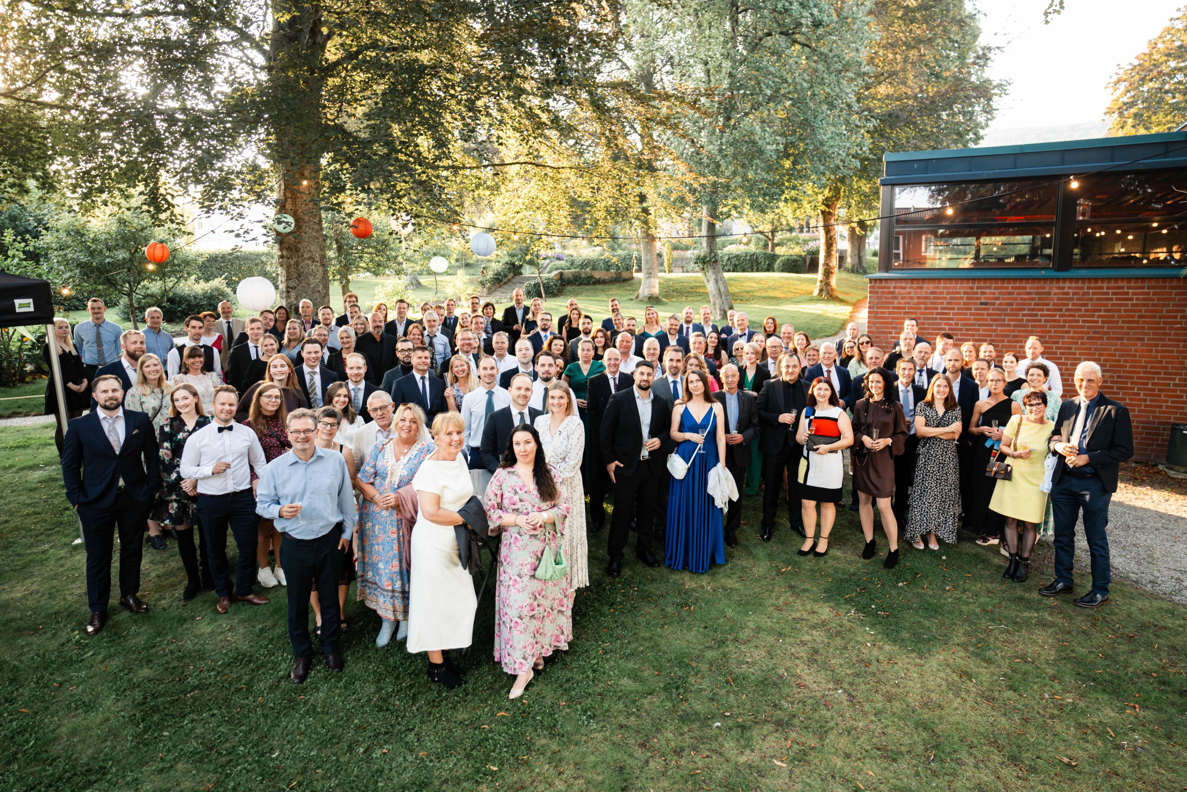 A group of pepole dressed for a party gatherd in a garden