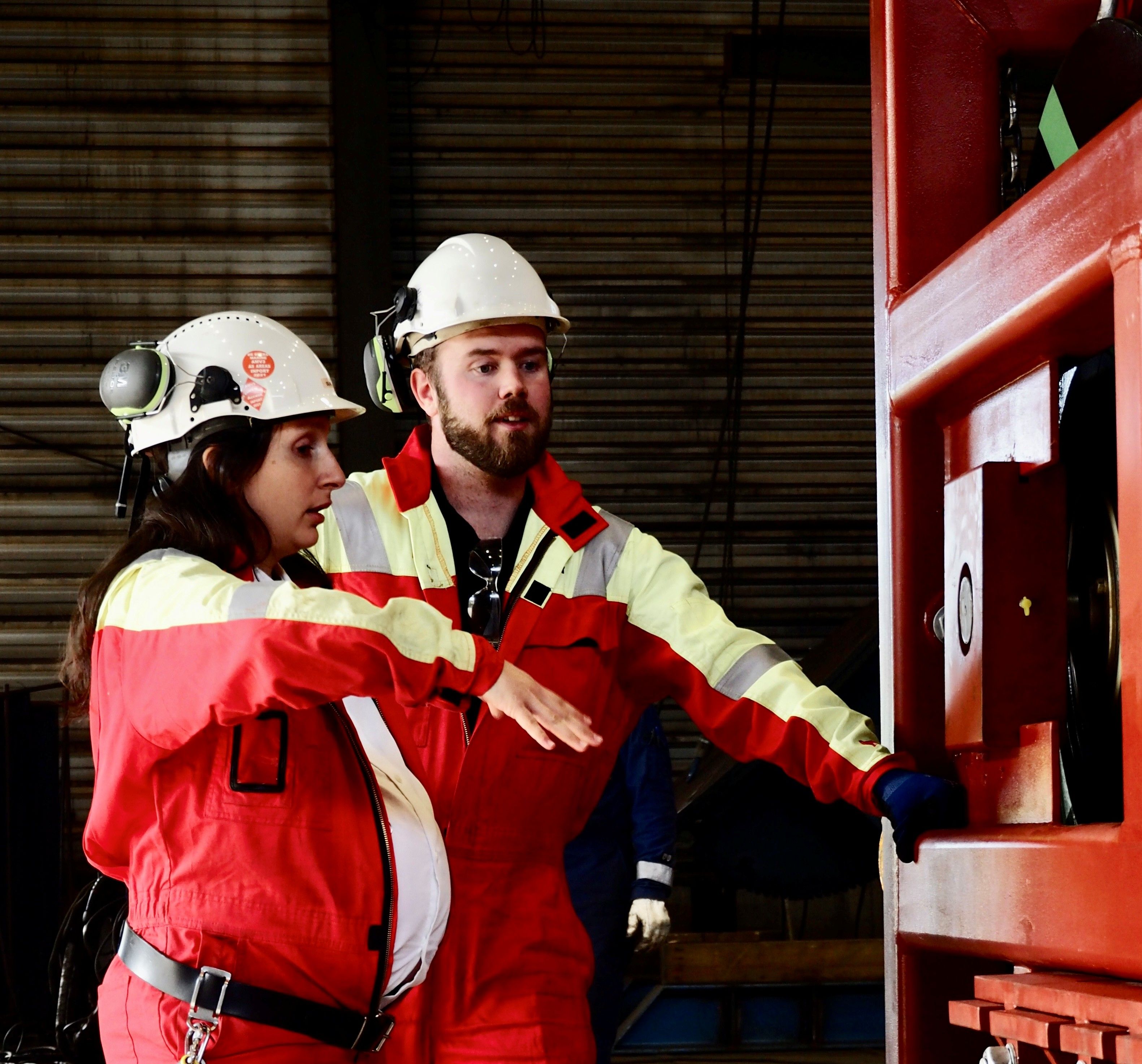 Pregnant woman and man in overalls working
