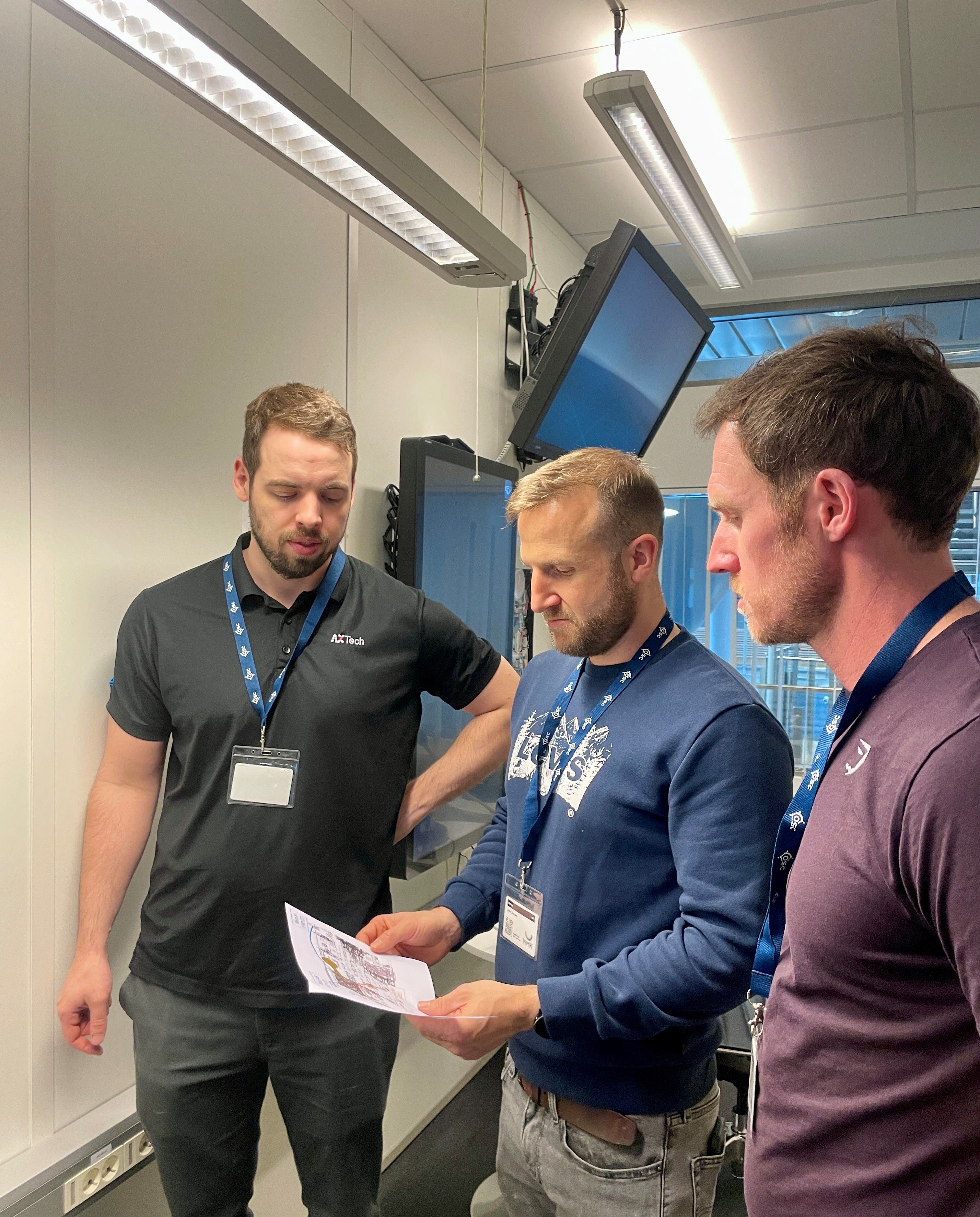 Three men looking at a paper