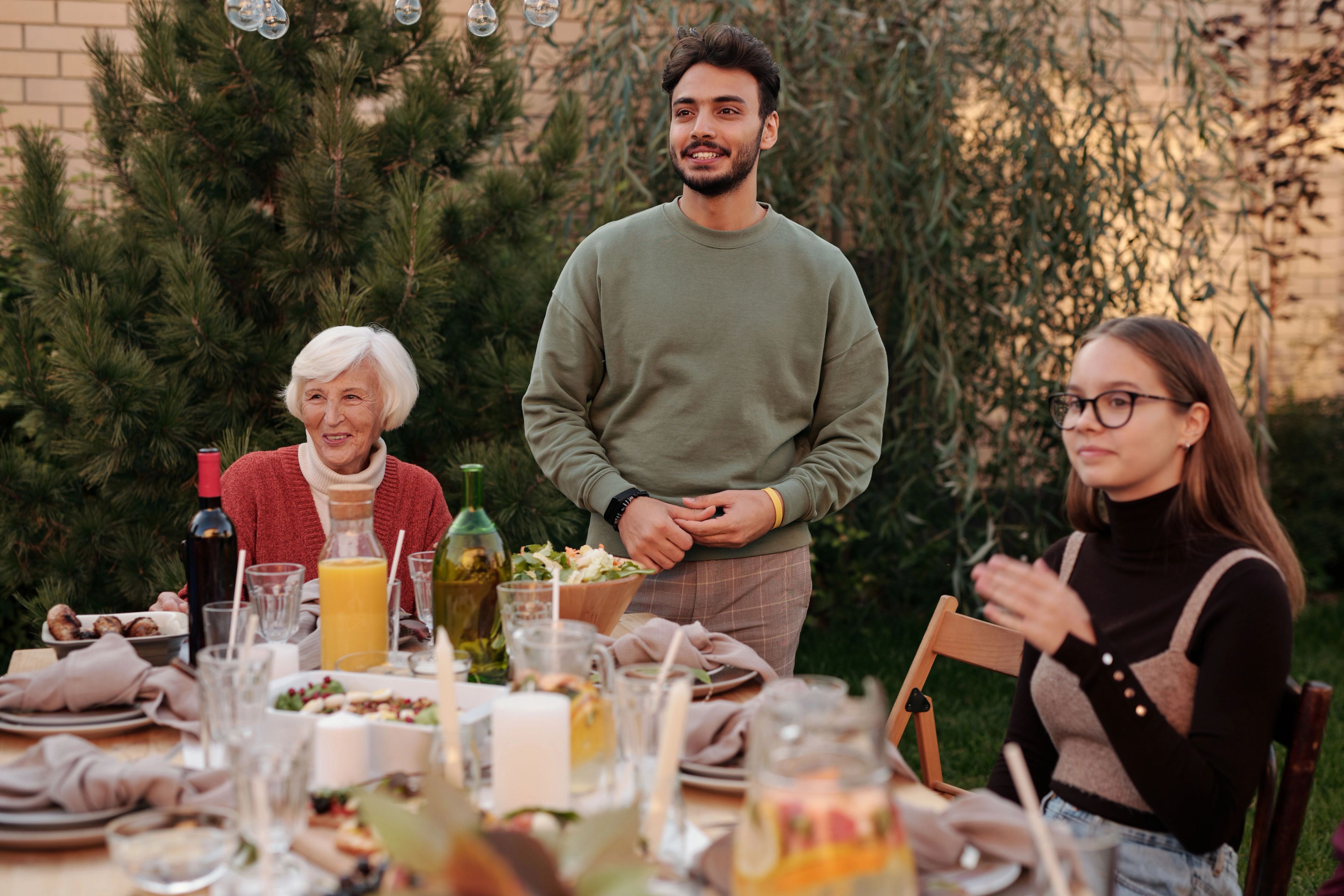 Young man looking at family at a full lunch table