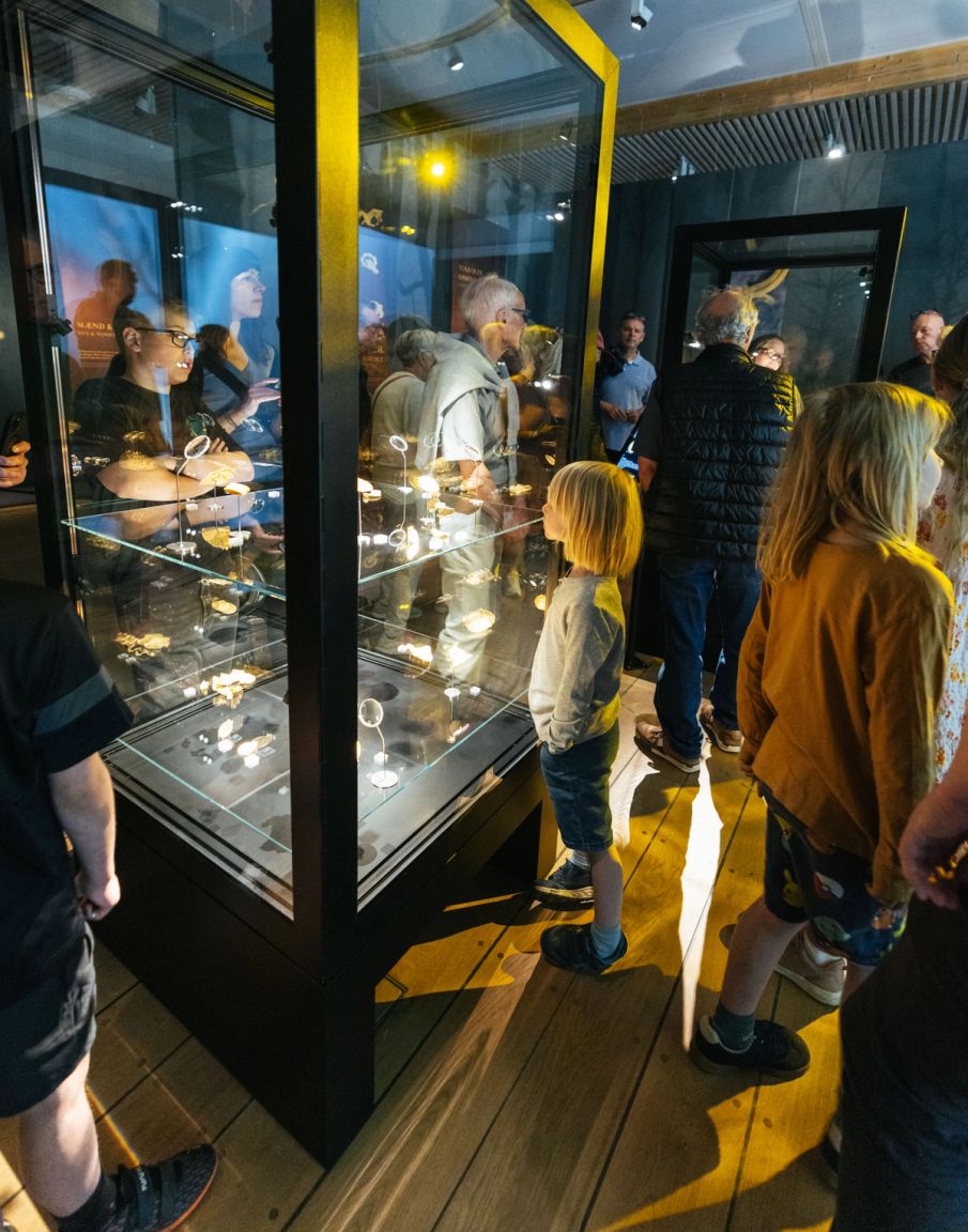 Lille dreng kigger på en guldskat i en montre