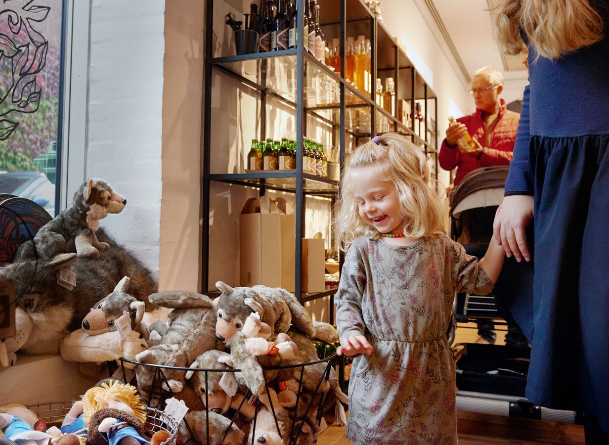Little blond girl standing next to a basket of toy wolves