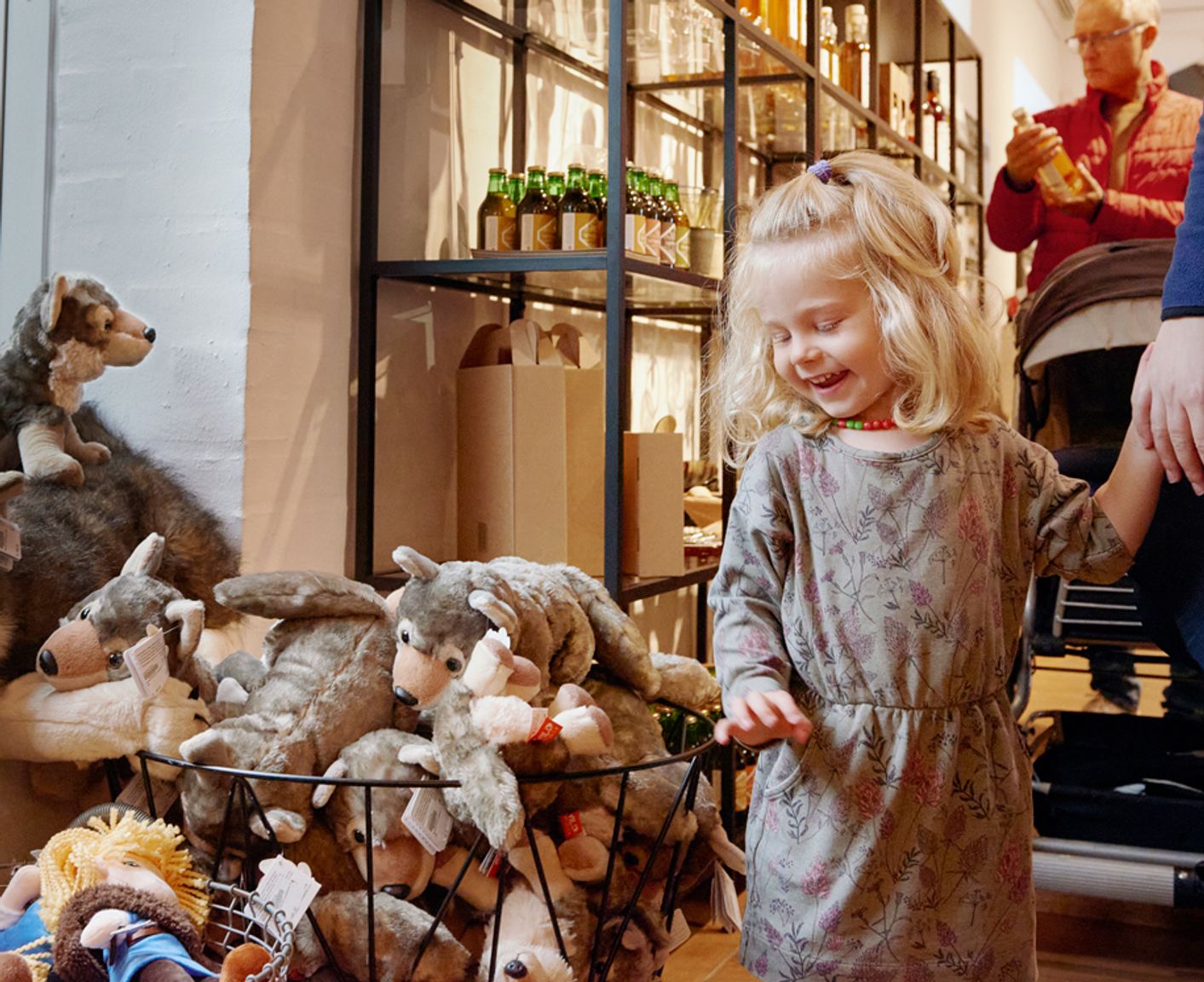 Lille lyshåret pige står ved siden af en kurv af ulvebamser