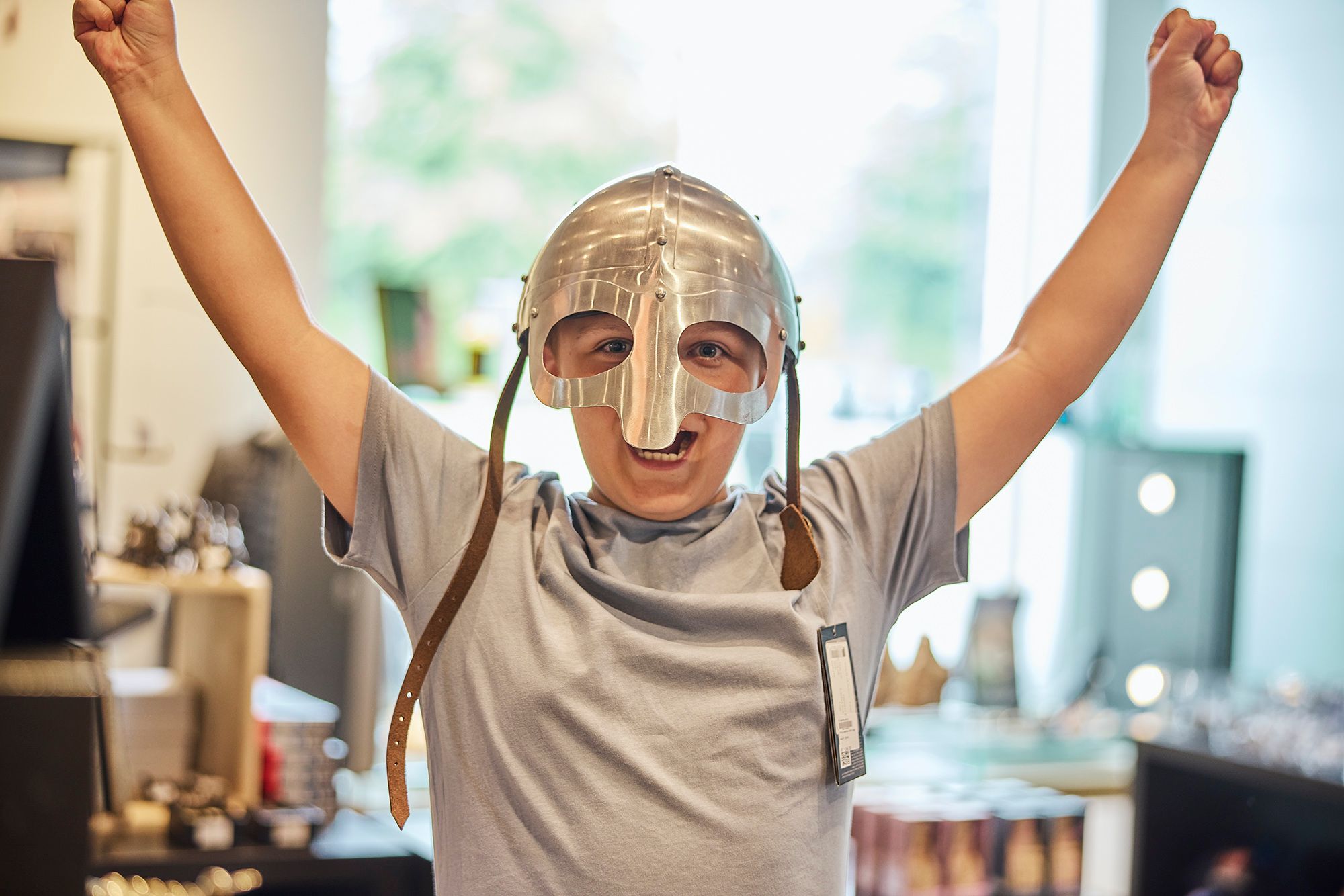 Dren med hjelm på og hænderne i vejret