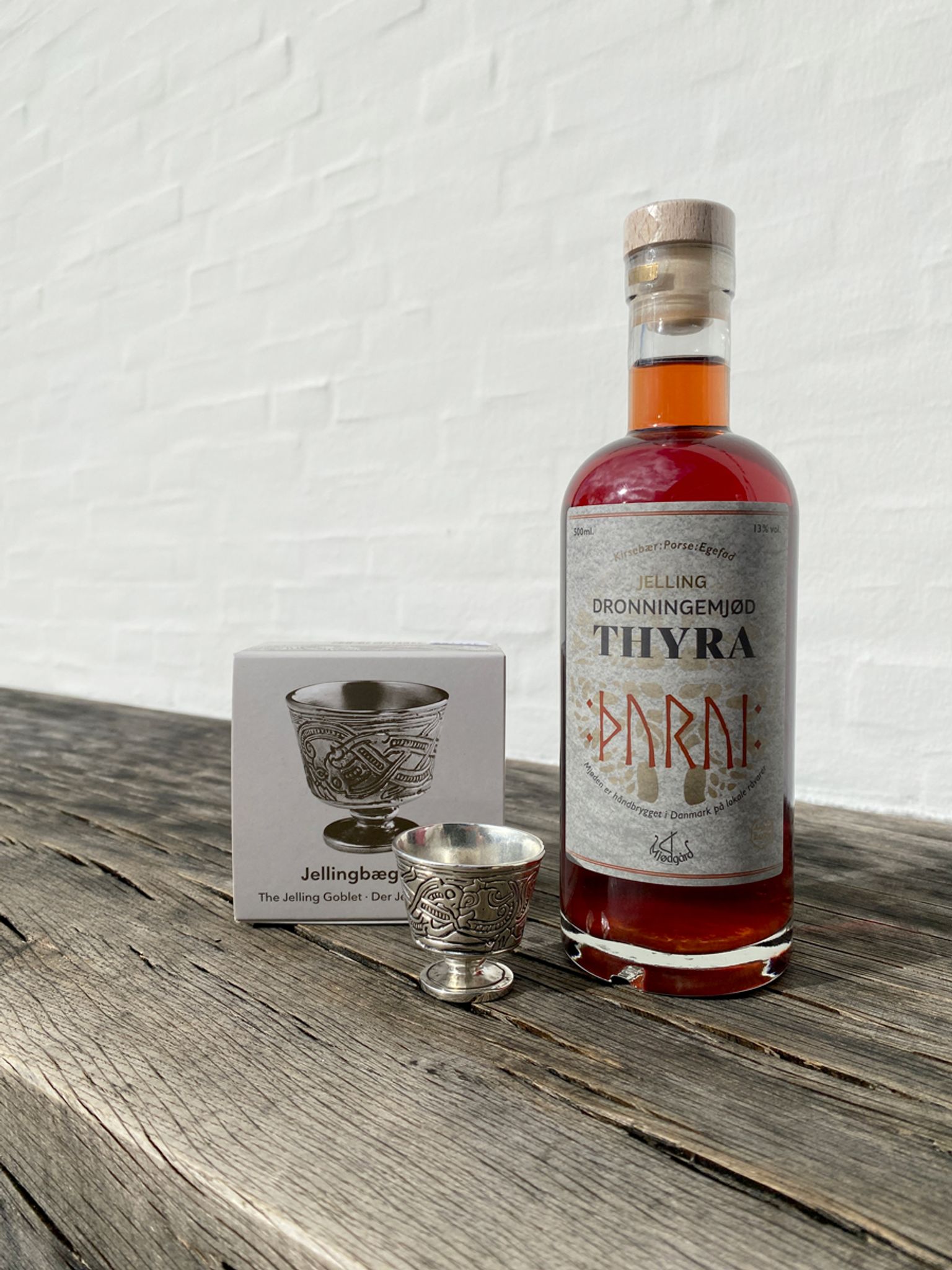 Flaske med Jelling Dronningemjød og en miniature version af Jellingbægeret