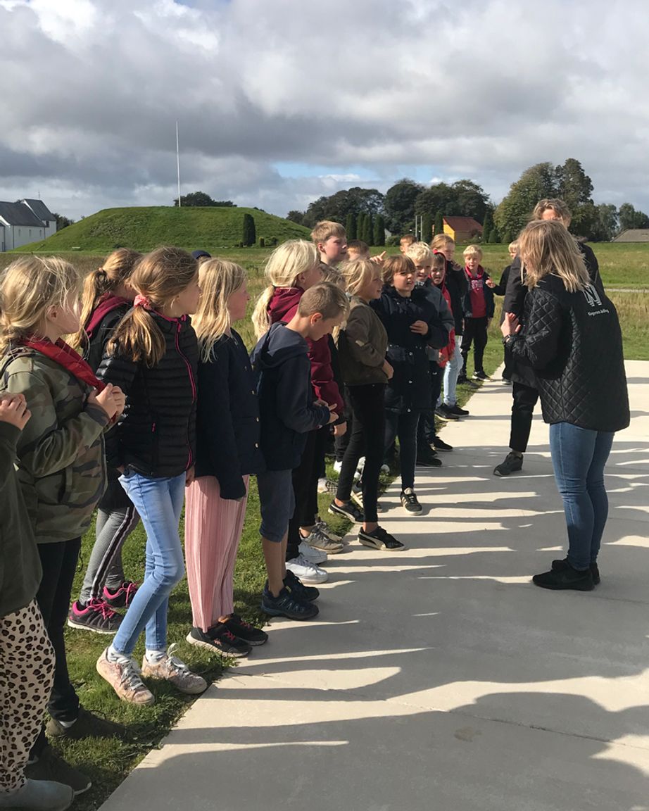 Elever står og lytter til en guide