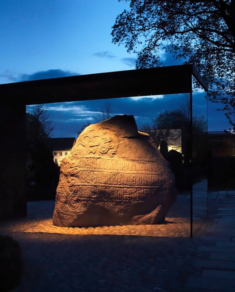 Den store jellingsten med lys på om aftenen