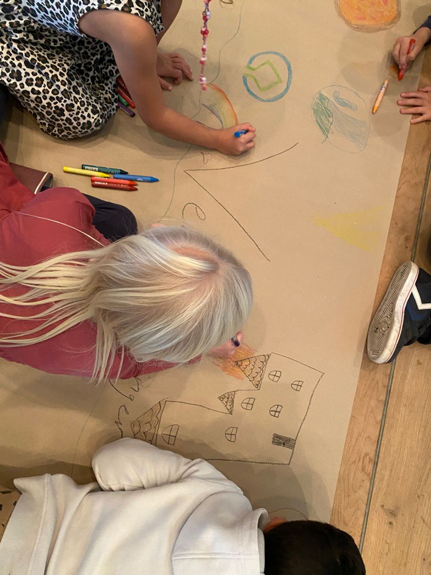 Skoleelever tegner på et stykke papir