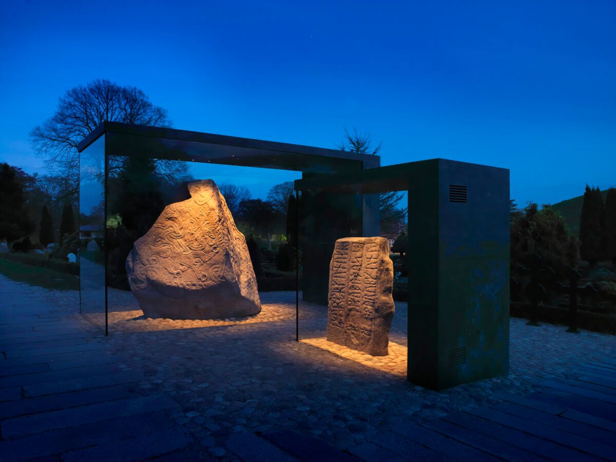 The Jelling stones in display case in the evening with lights on