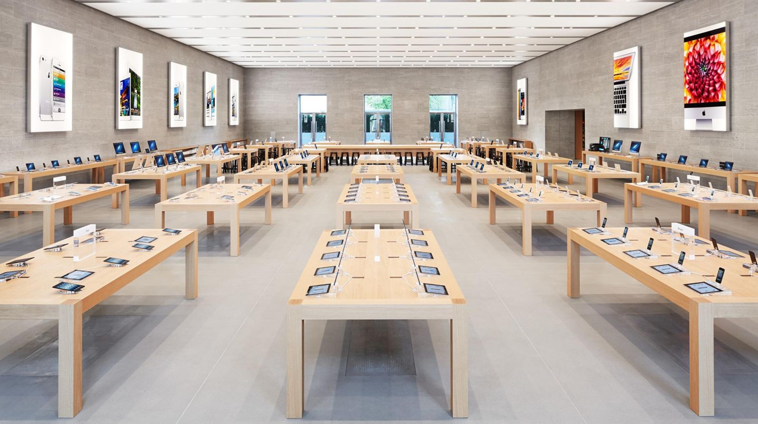 Inside an Apple Store, tables and chairs are set up, providing a welcoming space for customers to engage with products.