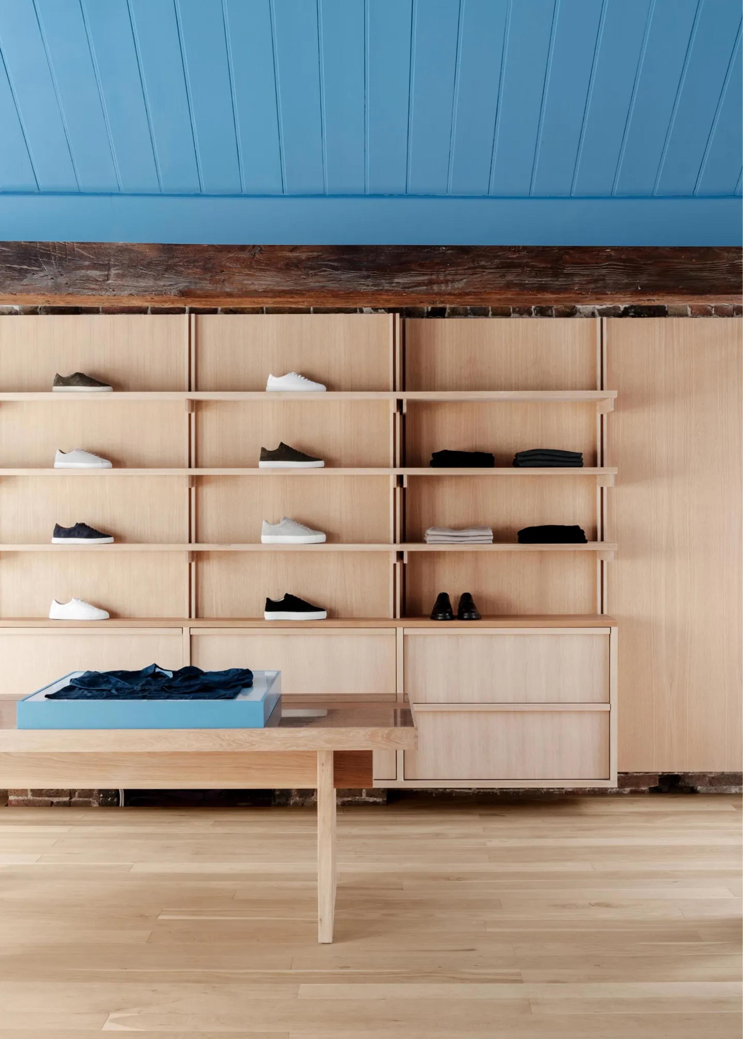 A Day’s March Store interior with wooden shelves displaying various objects, highlighted by tranquil blue walls.