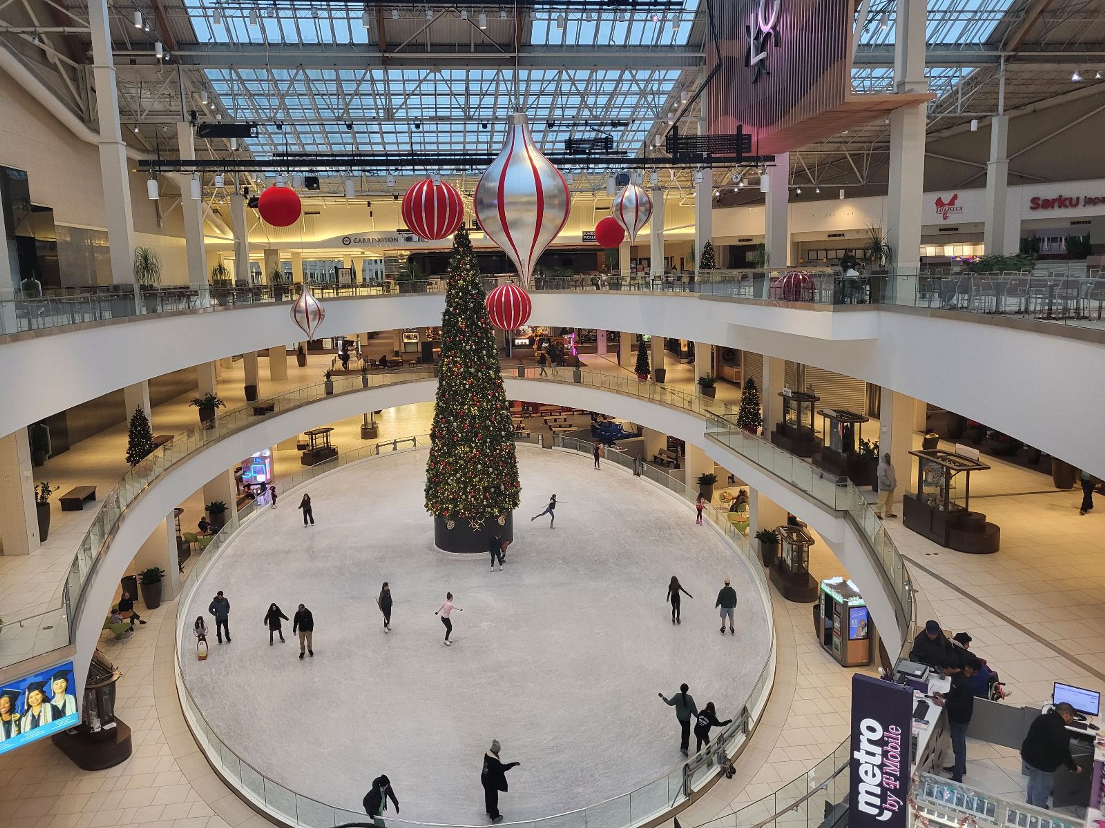 People ice skating around a Christmas tree inside the Lloyd Center