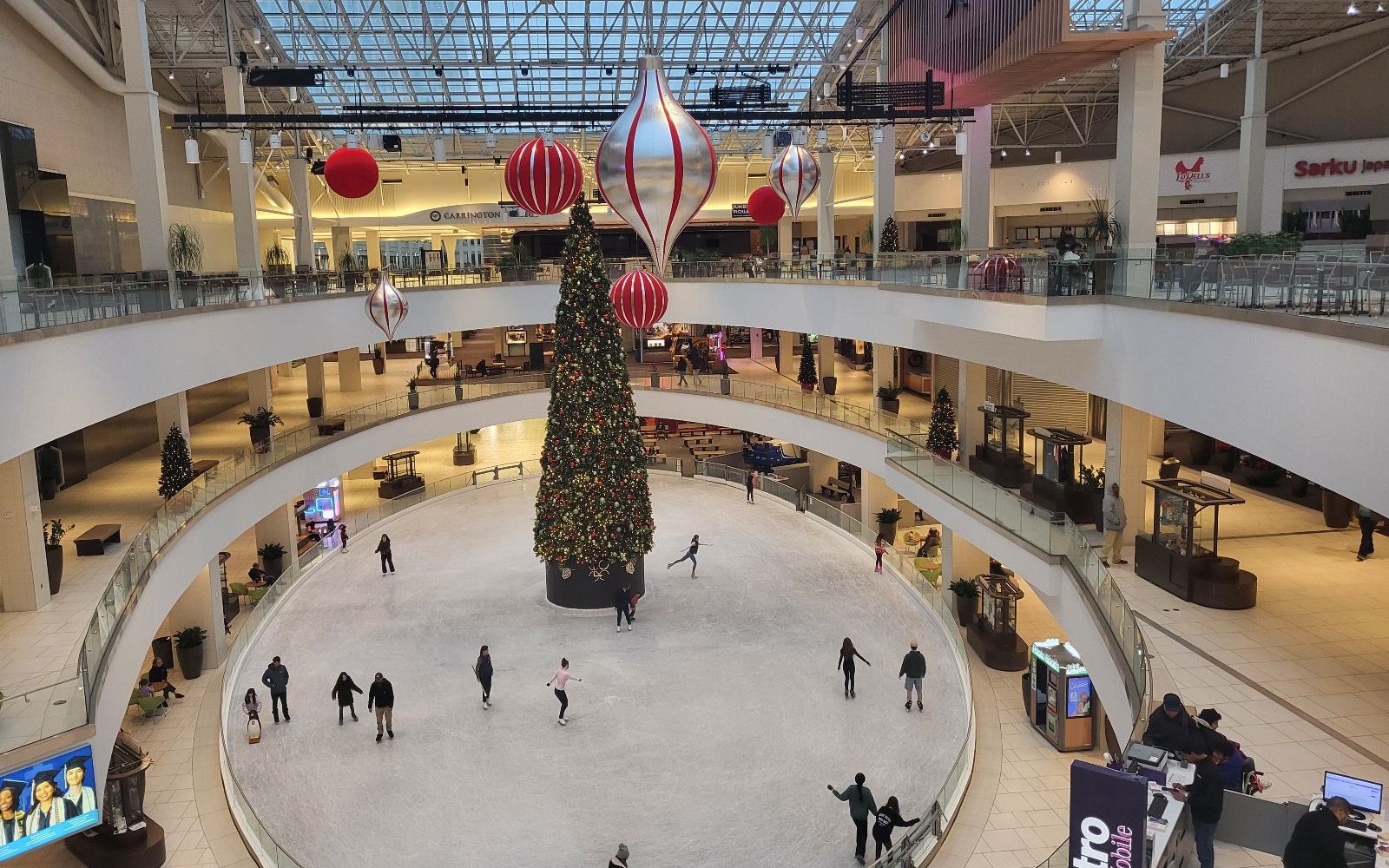 People ice skating around a Christmas tree inside the Lloyd Center