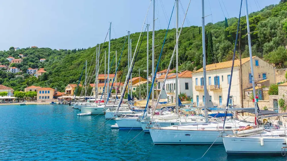 Photo of Kioni harbour on Ithaca island in Greece with sailing yachts anchored.