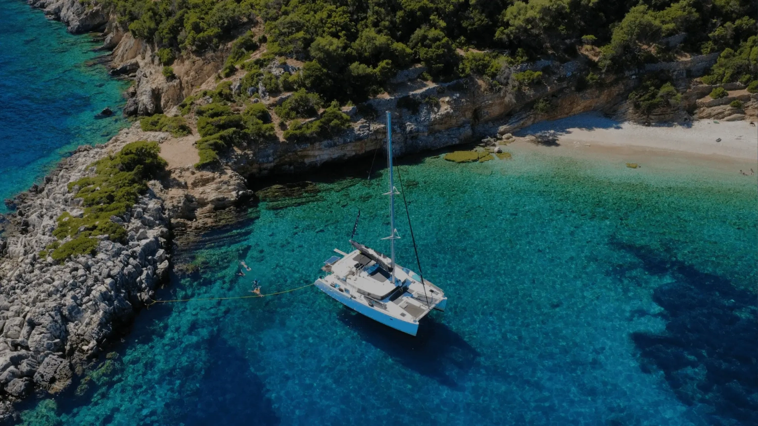 Group of friends enjoying sunset together aboard a private catamaran during a Mediterranean sailing holiday with Yacht Getaways.