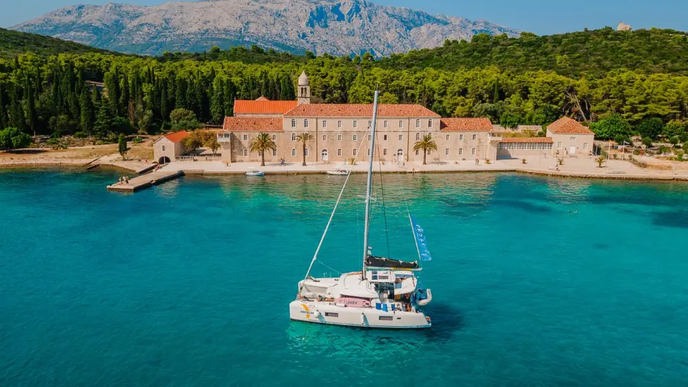 A yacht getaways luxury catamaran at anchor in a beautiful blue bay in Croatia for a luxury catamaran cruise around the Dalmatian islands.