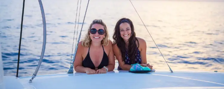 To woman smiling on a sailing holiday on a catamaran in the Mediterranean with Yacht Getaways.