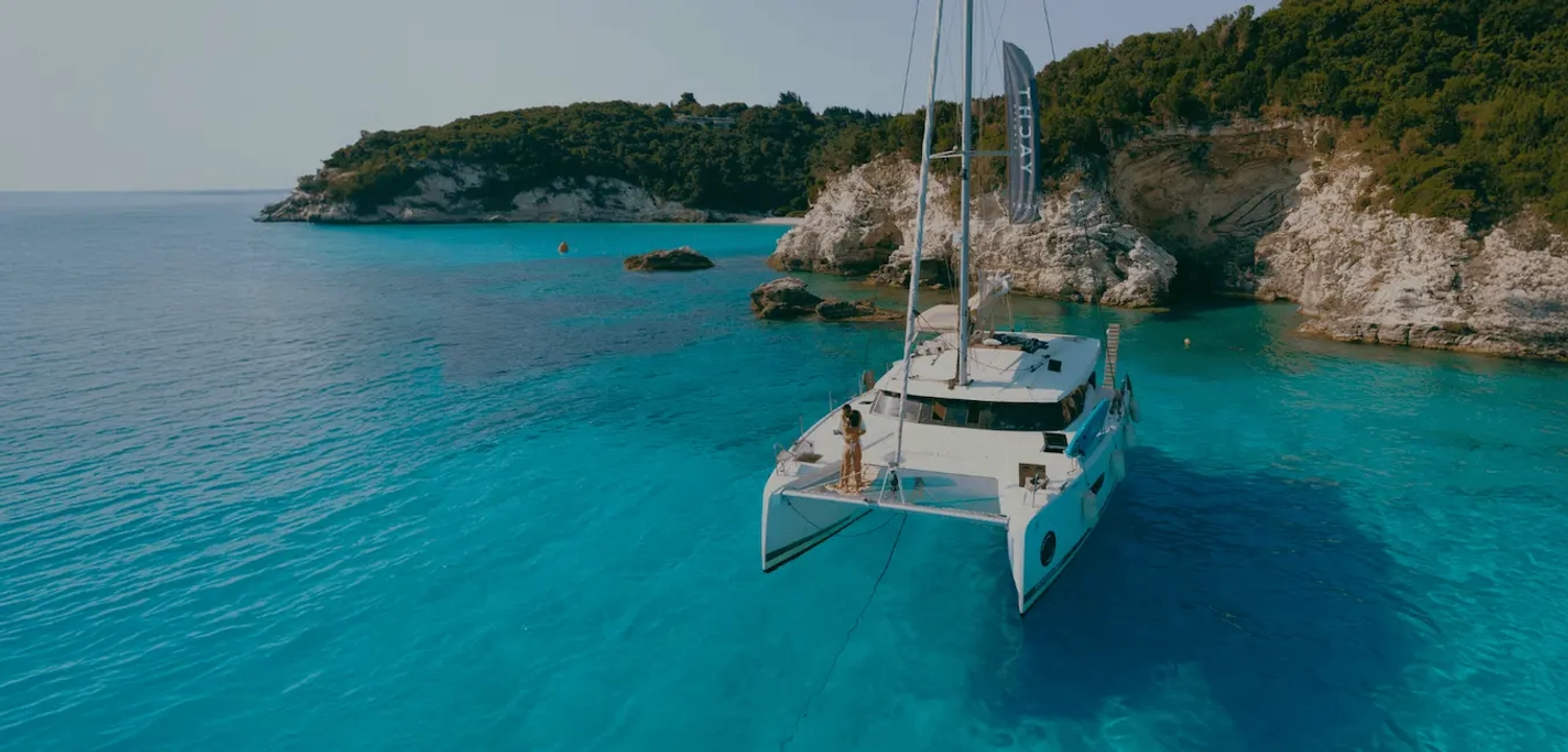 Group of friends enjoying sunset together aboard a private catamaran during a Mediterranean sailing holiday with Yacht Getaways.