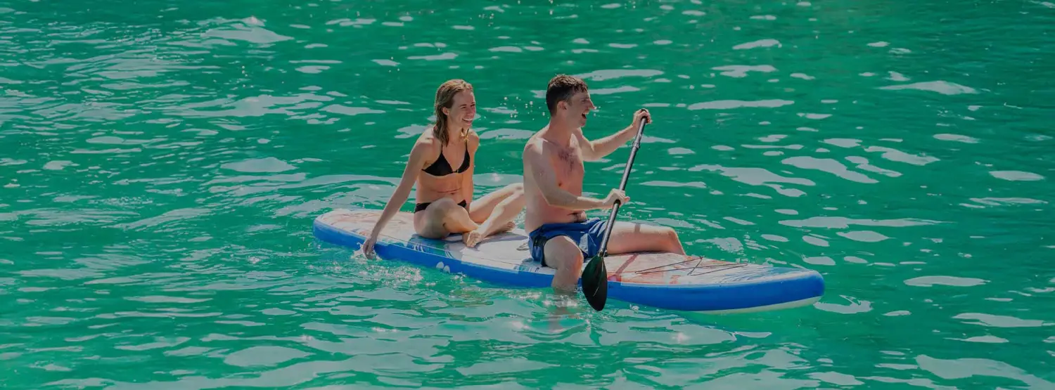 Couple on a paddle board having fun