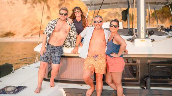 Group of friends pose for a photo on a yacht at sunset