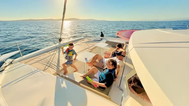 A family cruise in Croatia showing happy kids and parents relaxing on a luxury catamaran.