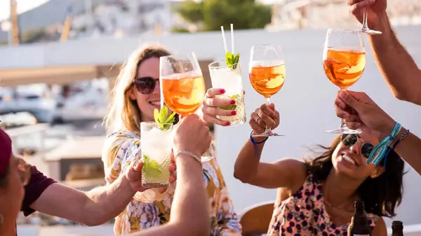 Friends cheers their drinks at sunset