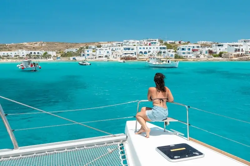 A woman sits on a catamaran looking out over Greece