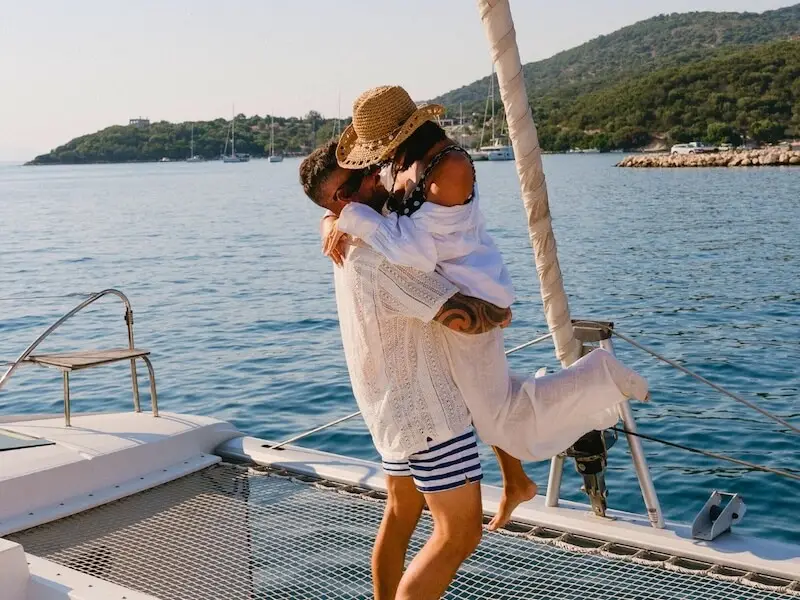 Couple sharing a romantic moment on the deck of a luxury catamaran during a Yacht Getaways sailing holiday in Croatia.