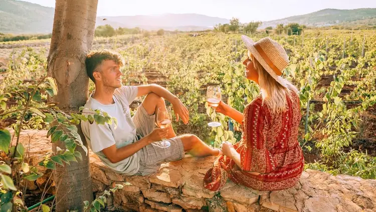 Couple enjoying a local wine tasting at a Croatian vineyard during their Yacht Getaways sailing holiday.