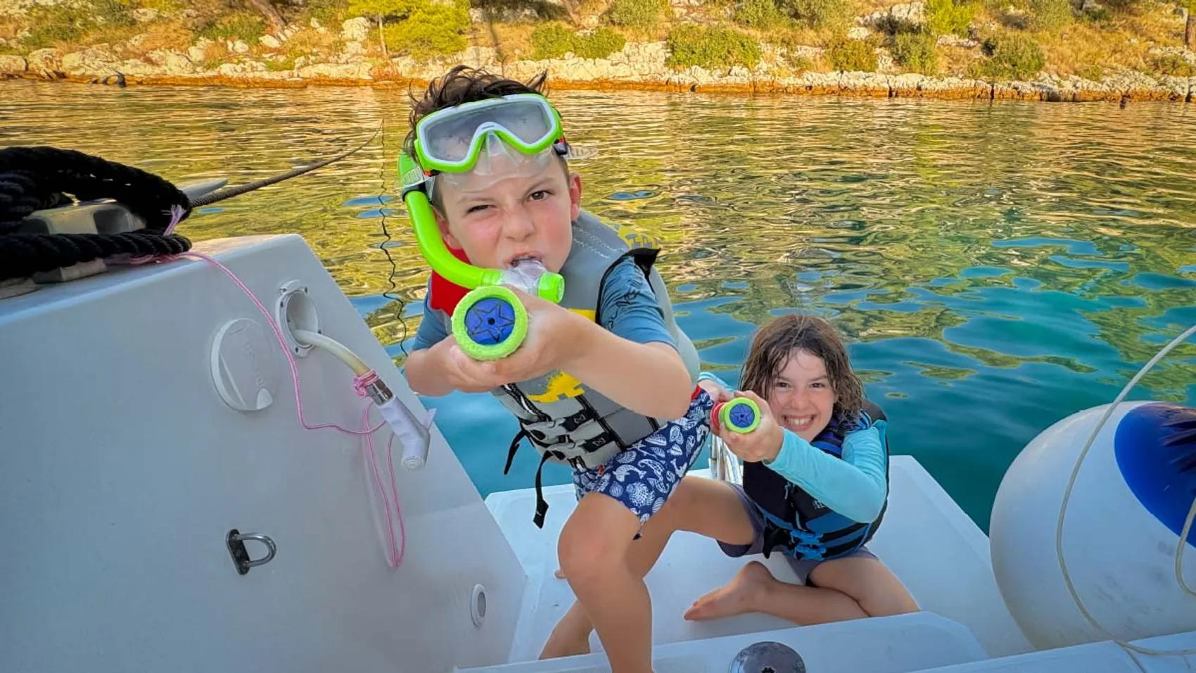 Kids with water guns on a catamaran