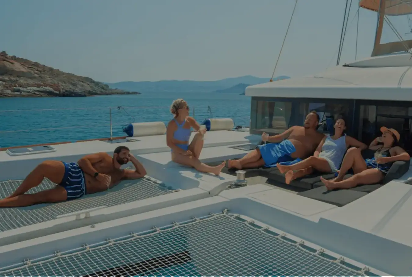 Group of people on a premium sailing vacation in Greece laughing and enjoying life on a catamaran.