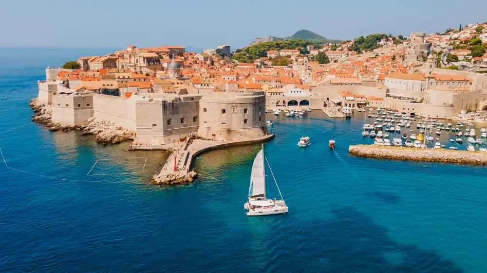 Dubrovnik Old Town with a yacht sailing in front of it