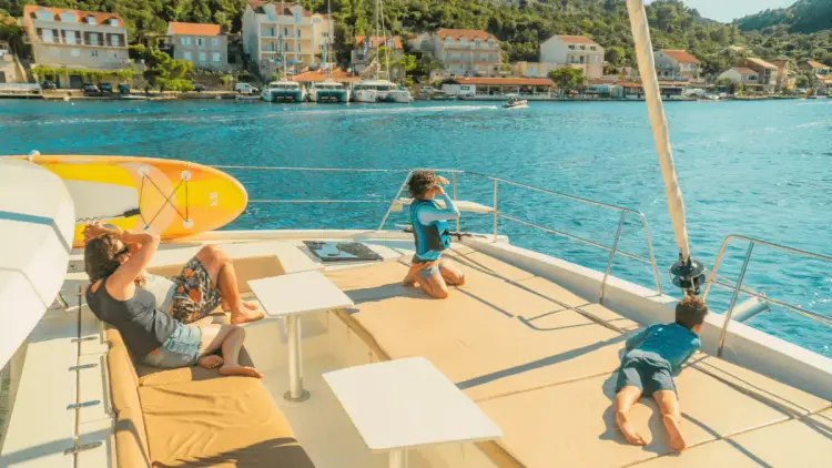 Family relax on the front of a catamaran