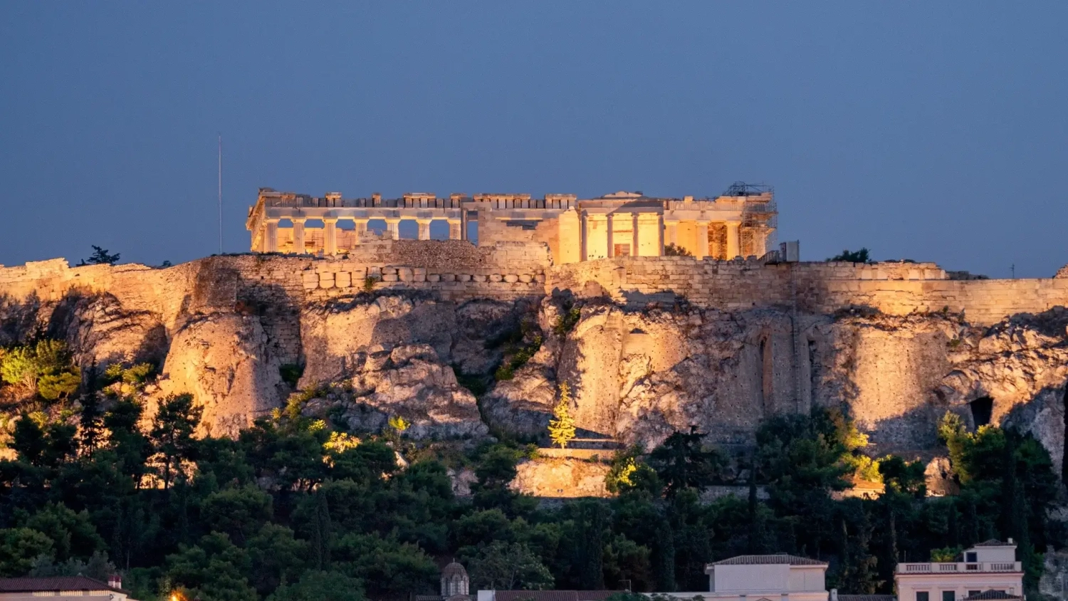 The Acropolis and Parthenon illuminated at dusk above Athens, Greece, with the ancient hill glowing against the evening sky. A strong image for an Athens, Greece travel guide covering the best places to visit in Athens, historic landmarks, sunset viewpoints, and why the city is worth visiting before a wider Mediterranean or Greek islands holiday.
