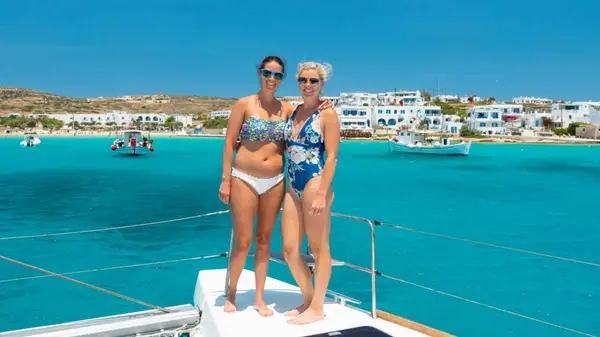 Two women pose for a photo on a yacht