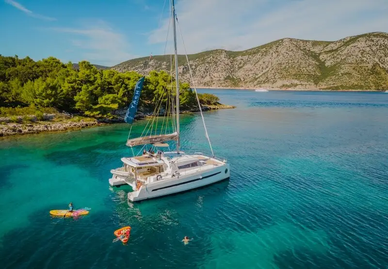 A luxury catamaran at anchor in Croatia with a family on vacation enjoying a family trip in the Mediterranean with yacht Getaways.