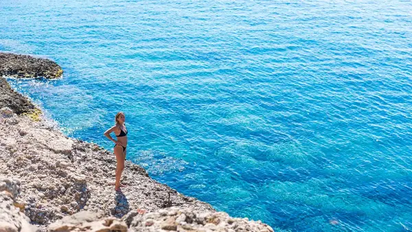 Woman standing on some rocks on the island of Dokos