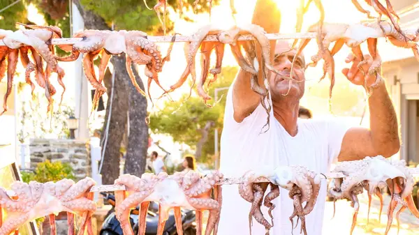 Man hanging squid to dry in Greece