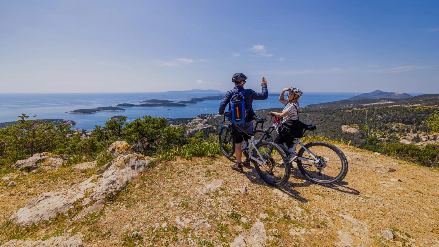 Couple of people on bikes in Croatia do a high five