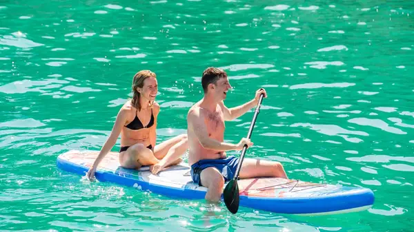 Couple paddle boarding in Greece