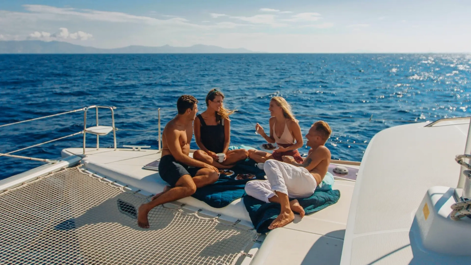 A group of travellers enjoy sunshine and blue seas while on a last-minute trip aboard a luxury catamaran cruise in the Mediterranean.