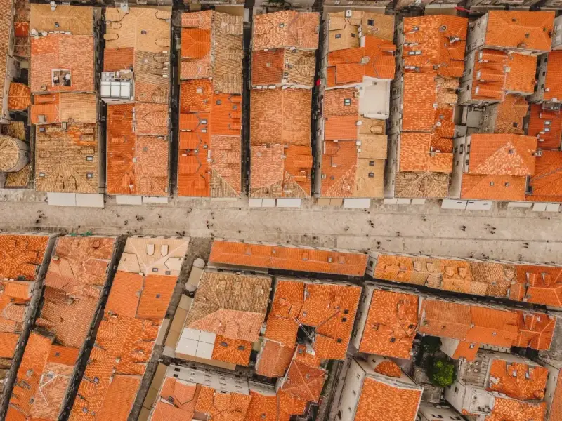 Aerial view of Dubrovnik Old Town rooftops and Stradun in Croatia, showing rows of terracotta tiles and historic stone buildings lining the streets inside the famous medieval city walls. The distinctive rooftops are one of the most recognisable features of Dubrovnik and highlight the historic character of this UNESCO-listed Croatian city.