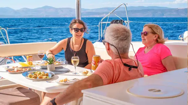 Group of people have drinks and nibbles on a yacht