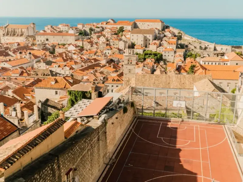 Panoramic view over Dubrovnik Old Town in Croatia showing terracotta rooftops, historic stone buildings and the Adriatic Sea beyond the famous city walls. This perspective highlights the UNESCO-listed Dubrovnik Old Town and captures one of the most iconic views travellers experience when exploring the city while walking the walls, one of the top things to do in Dubrovnik
