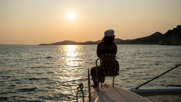 Woman sitting on a yacht at sunset