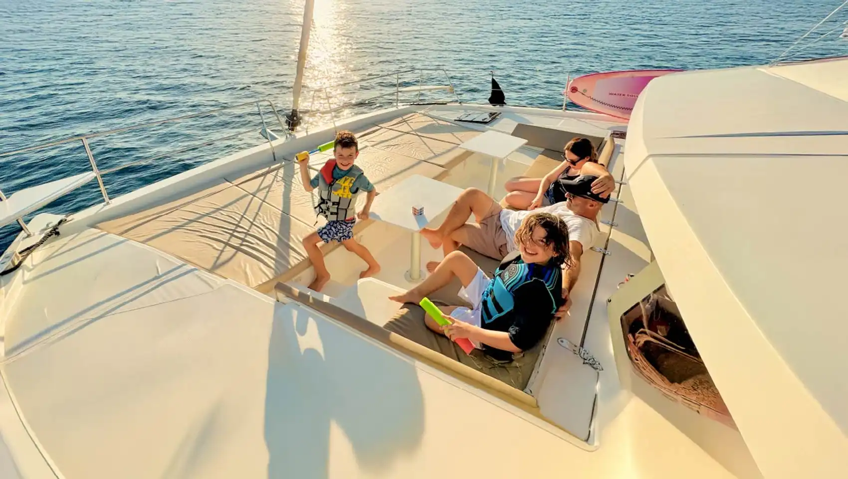 Family relax on the front of a catamaran